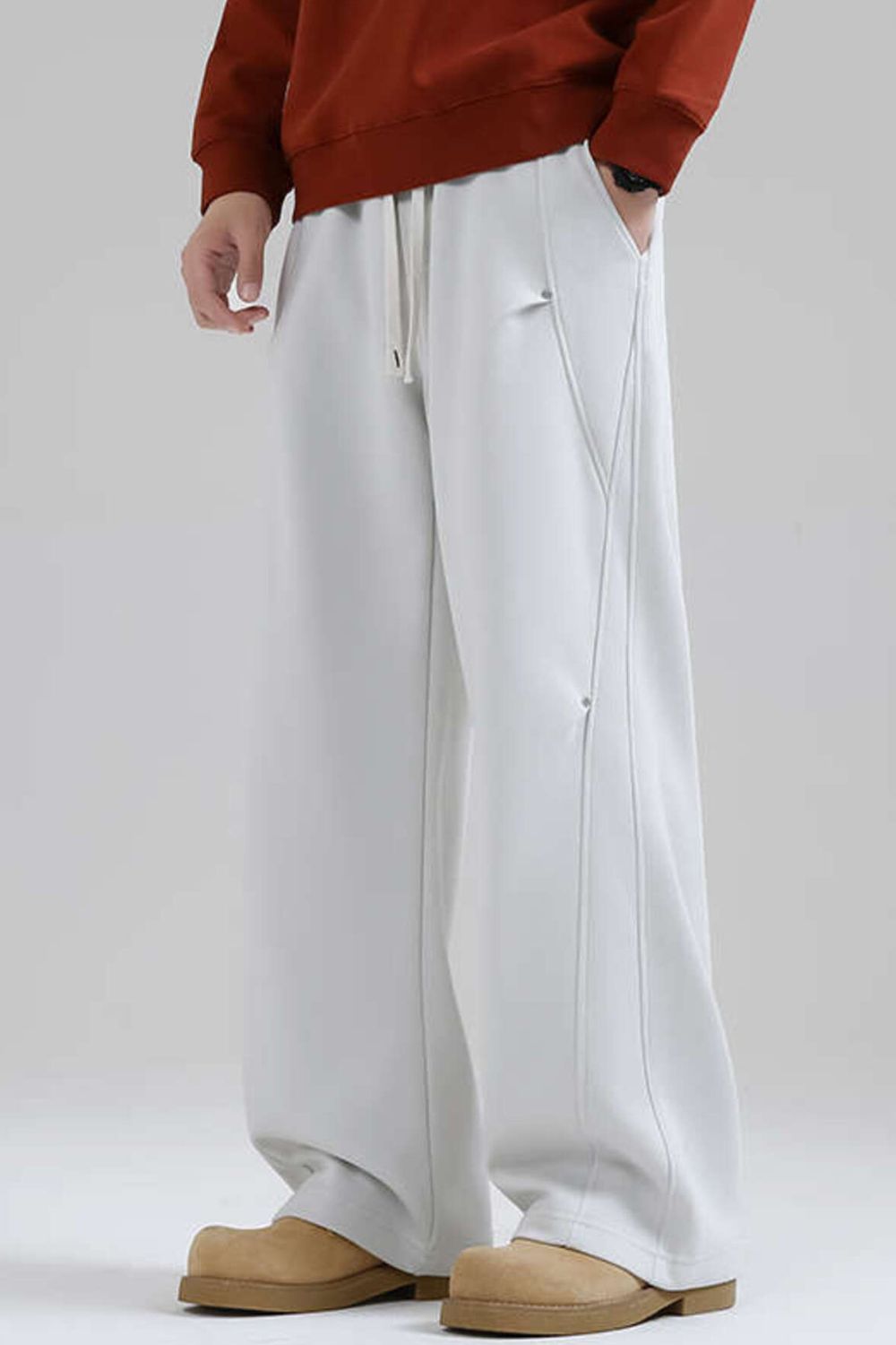 Men's white drawstring sweatpants with side seam details and pockets.