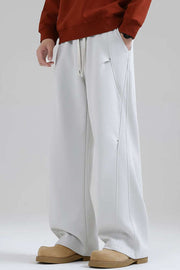 Men's white drawstring sweatpants with side seam details and pockets.