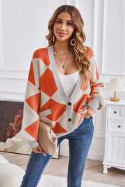 Diamond knit balloon sleeve cardigan in orange and cream with grey trim.