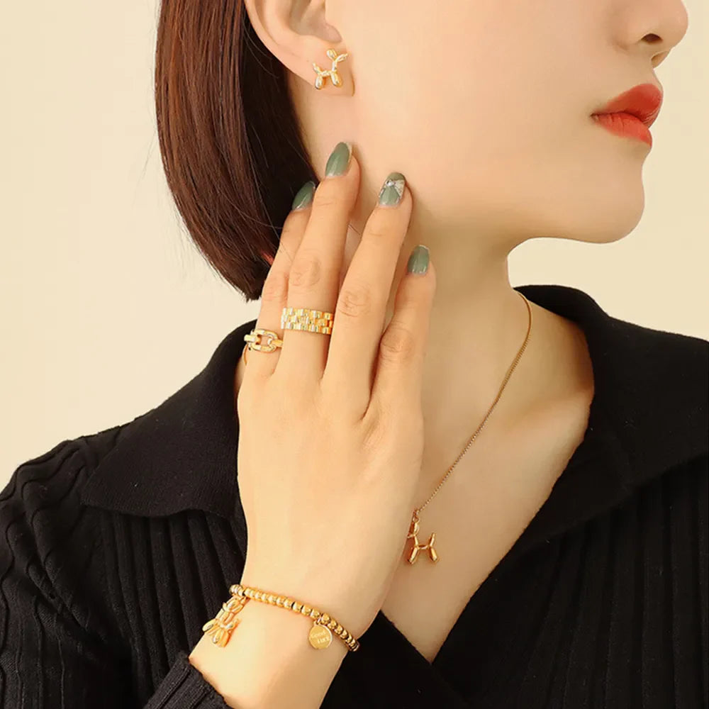 Gold balloon dog sculptural stud earrings with matching necklace and bracelet.