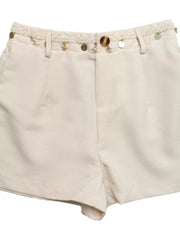 Embellished linen shorts in cream with star and coin charms on the waistband.