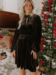 Black velvet mock neck dress with balloon sleeves and a tie waist detail.
