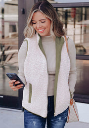 Reversible quilted sherpa vest in cream with olive green lining and utility pockets.