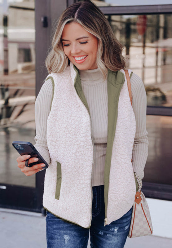 Reversible quilted sherpa vest in cream with olive green lining and utility pockets.