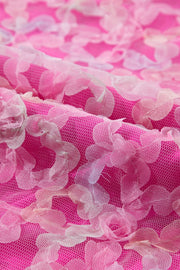 Fuchsia pink mesh blouse with floral appliqué detail.