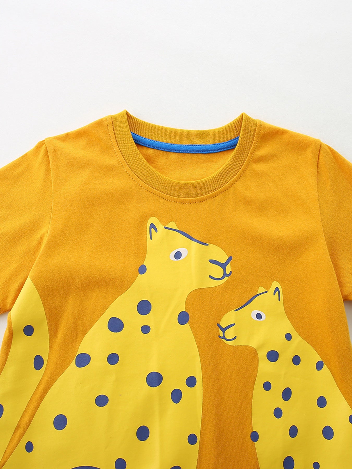 Toddler yellow cotton t-shirt with playful leopard graphic and blue neckline trim.