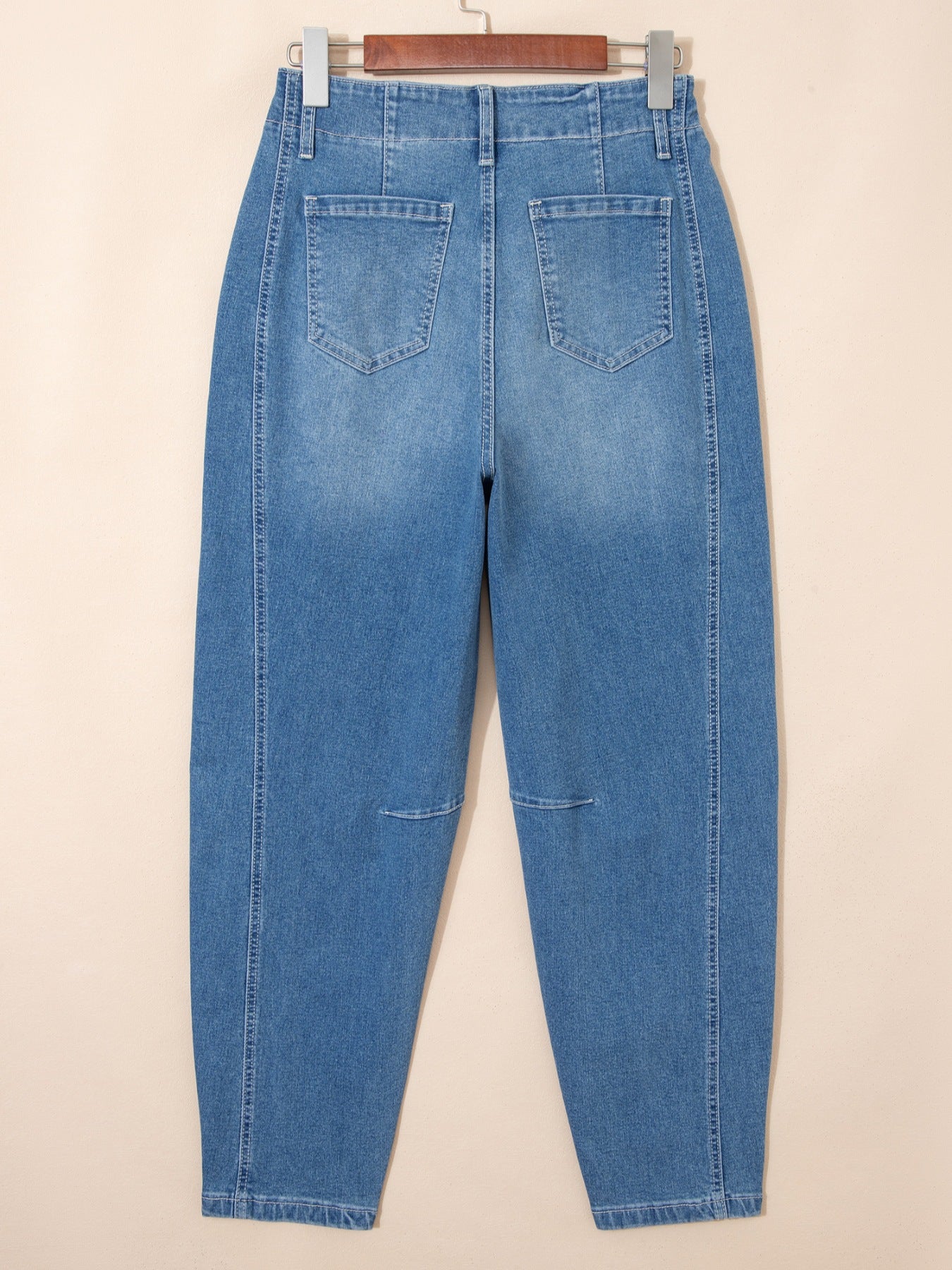 High-waisted blue denim barrel jeans with cuffed ankles and subtle knee details.