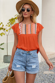 Orange embroidered yoke ruffle sleeve blouse with geometric pattern detail.