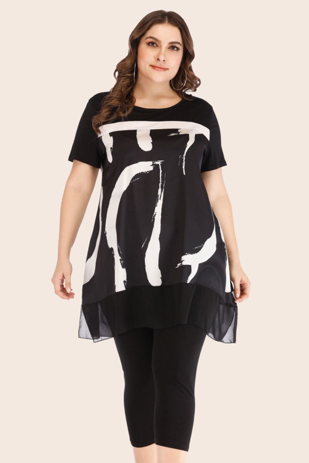 Black tunic with brushstroke print and sheer hem over matching leggings.