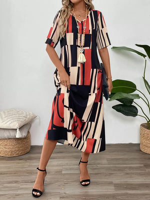 Geometric V-neck midi dress in dark blue, red, and beige with short sleeves and a relaxed fit.