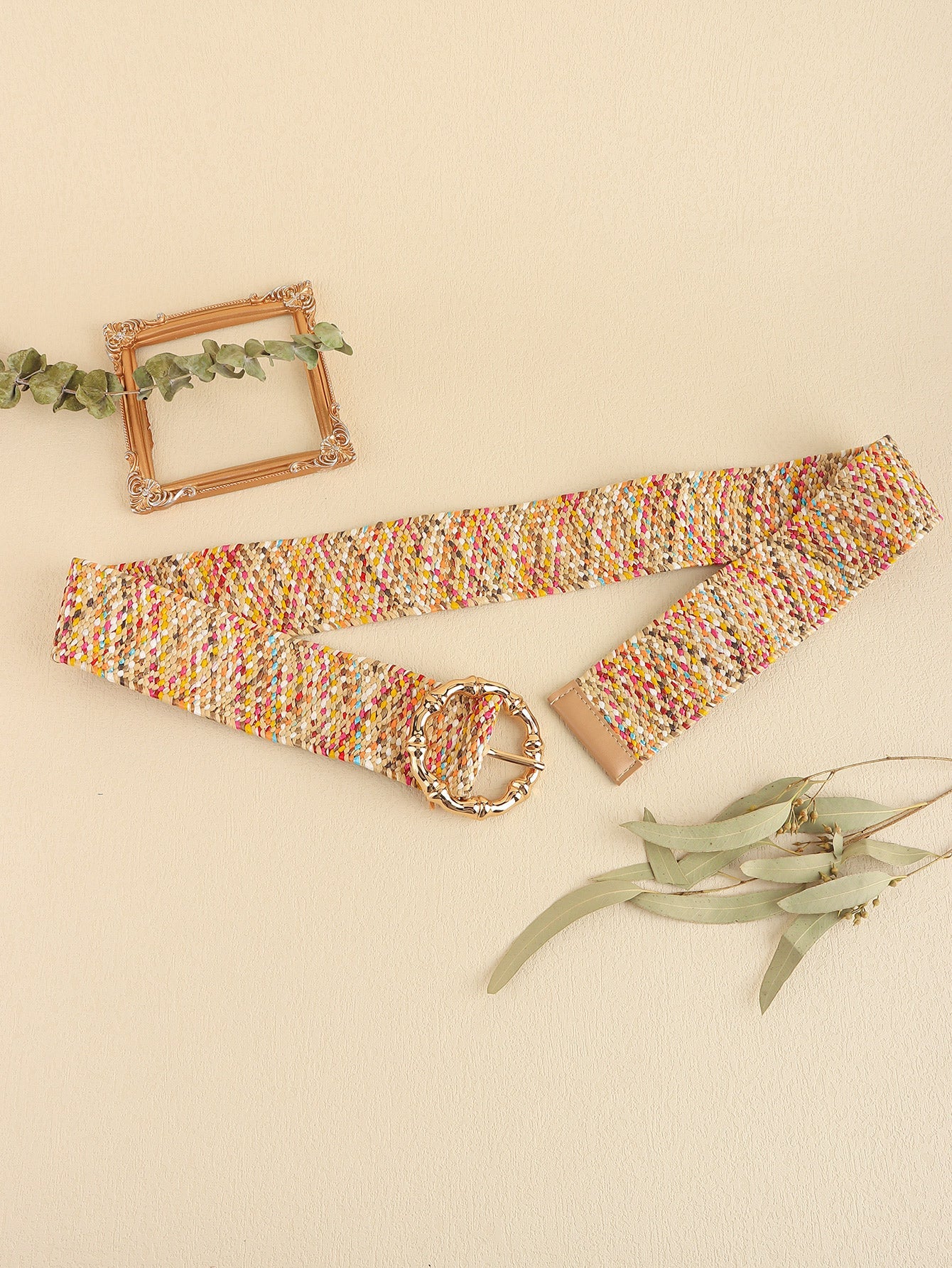 Woven raffia belt in multicolor with a sculpted gold buckle and tan leather trim.