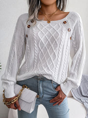 White cable-knit sweater with buttoned shoulder detail and diamond pattern.