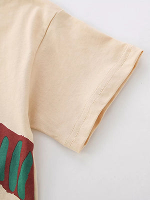 Cream cotton baby tee with abstract red and green graphic detail.