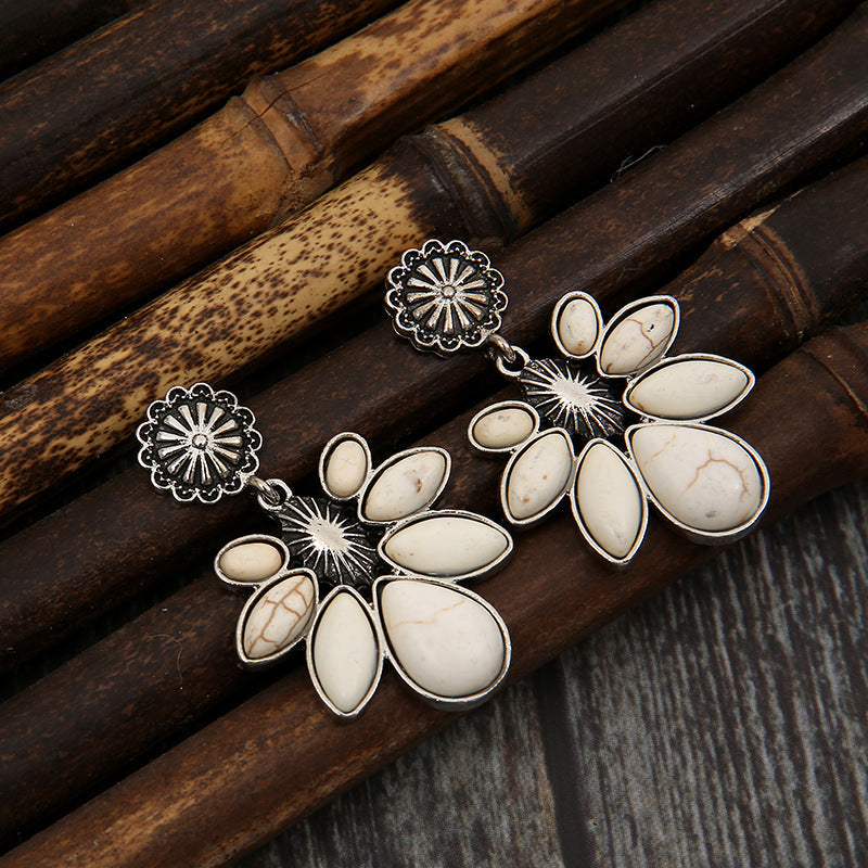 Floral drop earrings with white stones and silver alloy flower details.