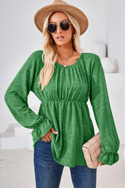 Green peasant blouse with gathered neckline, cinched waist, and ruffled cuffs.