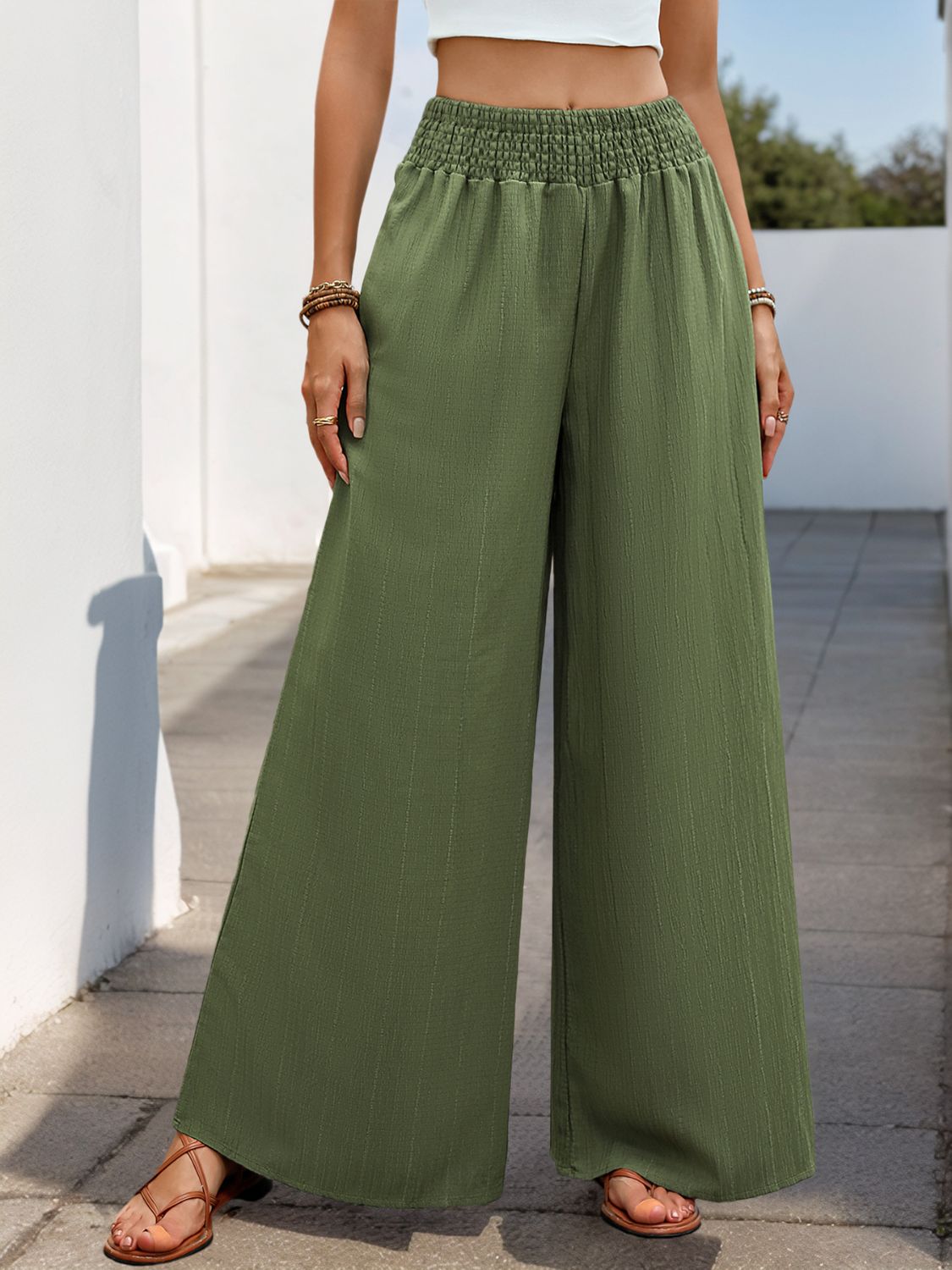 Moss green textured palazzo trousers with elastic waist and wide legs.