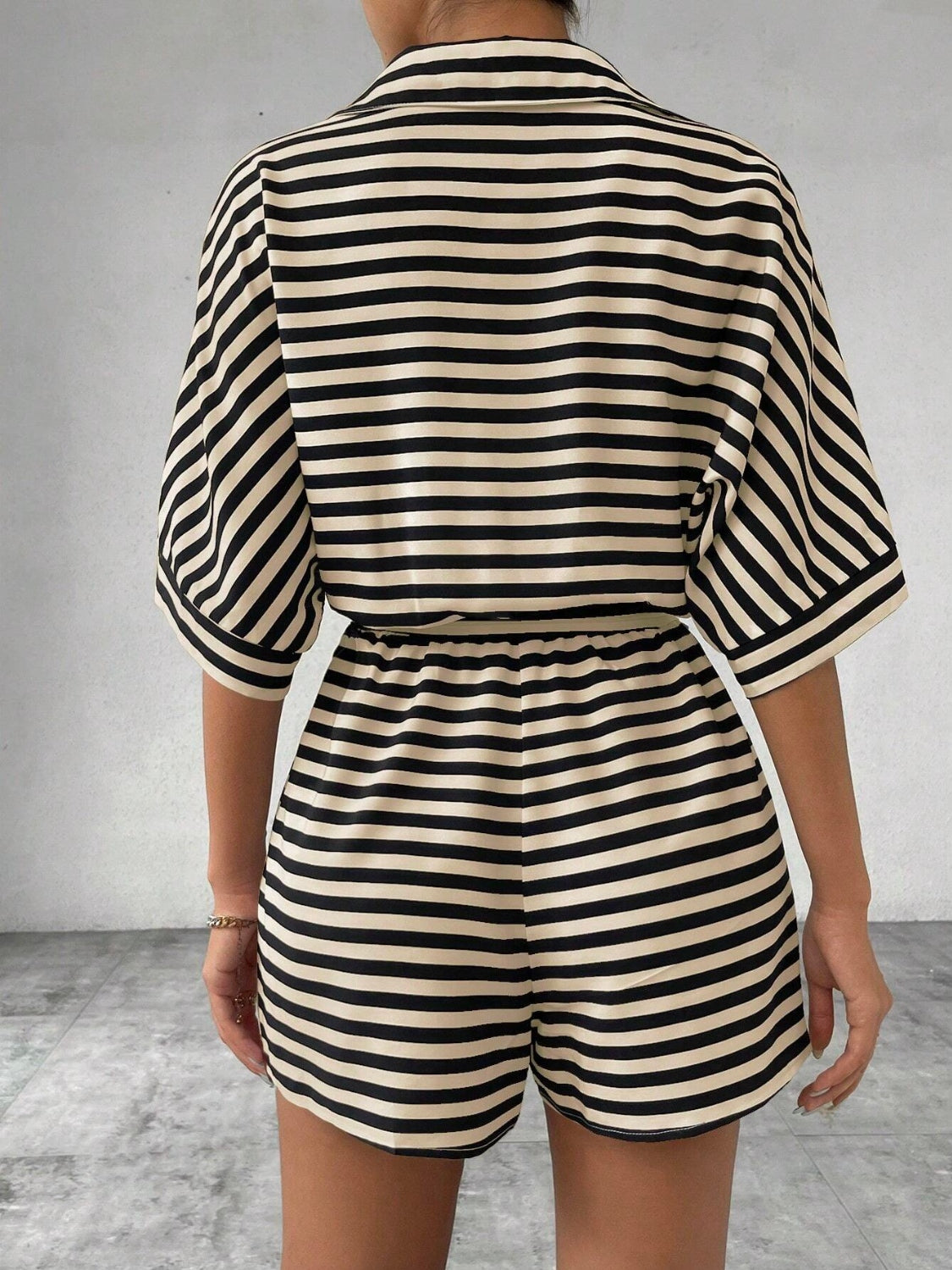 Black and tan striped romper with short sleeves and elastic waist shorts.