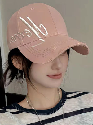 Pink cotton baseball cap with embroidered script and distressed details.