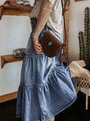 Tiered denim maxi skirt in medium wash, featuring ruffled tiers and a button-front detail.