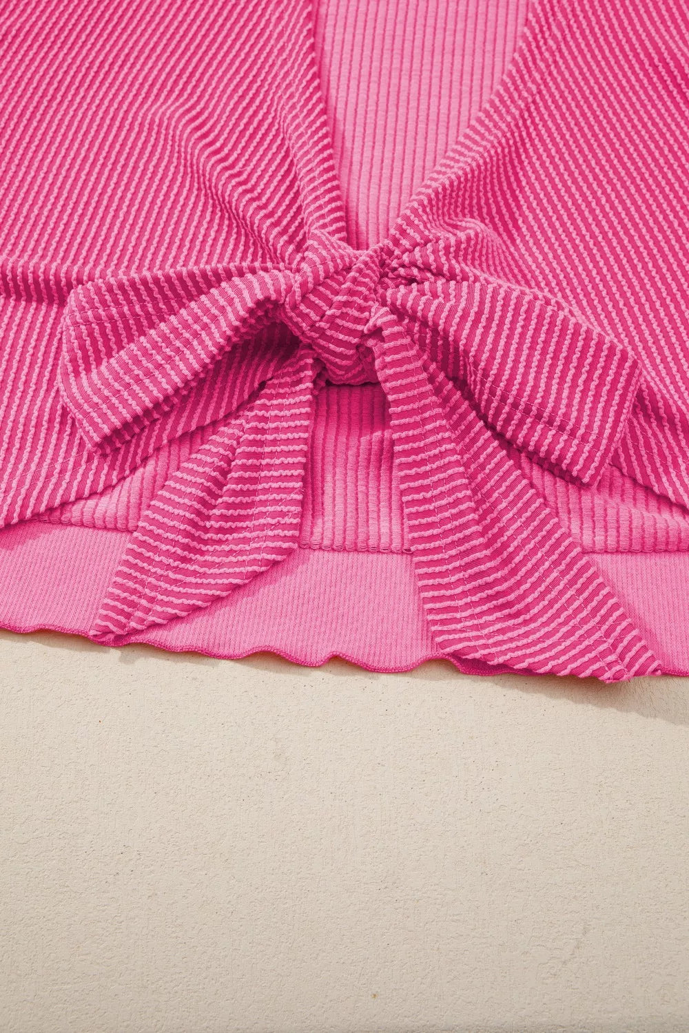 Pink ribbed maternity t-shirt with a tie-front bow detail