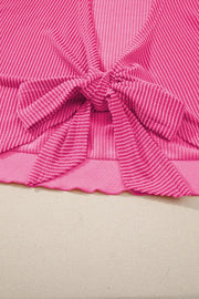 Pink ribbed maternity t-shirt with a tie-front bow detail