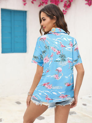 Sky blue camp collar shirt with flamingo and tropical print, short sleeves, buttoned front.