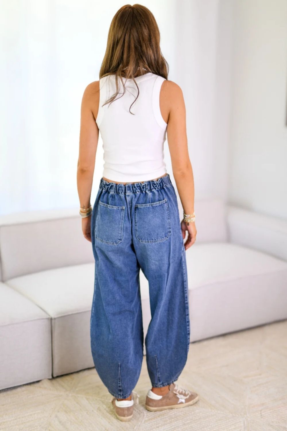 Balloon-leg denim jeans in medium wash with drawstring waist and back pockets.