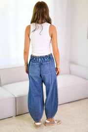 Balloon-leg denim jeans in medium wash with drawstring waist and back pockets.