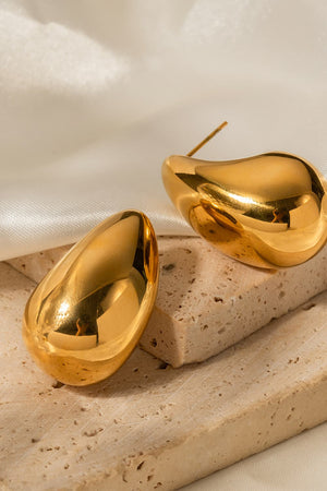 Sculptural gold teardrop stud earrings with a polished finish.