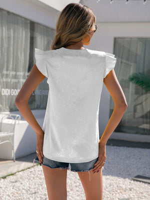 White jacquard blouse with flutter sleeves and a subtle floral pattern.