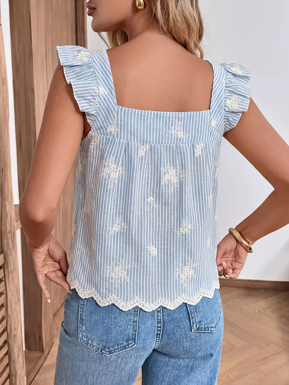 Embroidered striped peplum blouse with ruffled sleeves and eyelet hem.