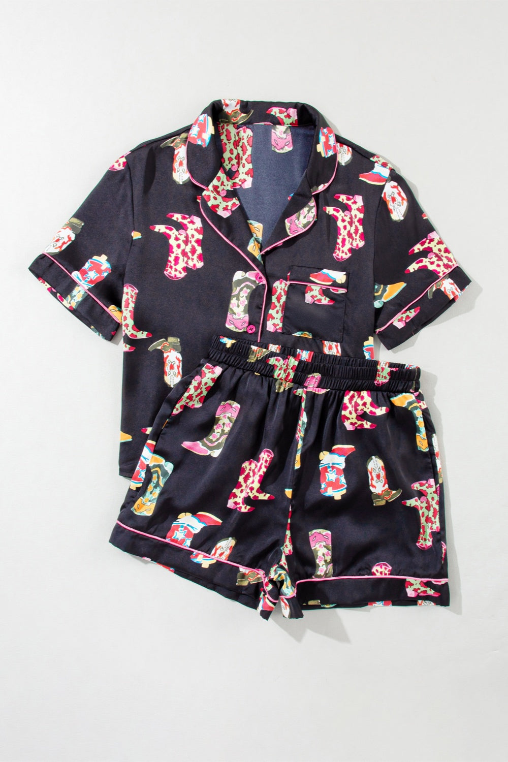 Black silk pajama set with colorful boot print and pink piping.