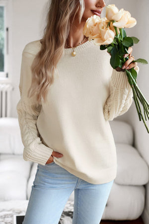 Cream cable-knit sleeve relaxed fit sweater with crew neck and ribbed cuffs.
