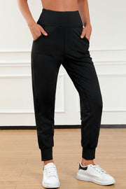 Black joggers with performance fit, elastic waistband, and side pockets.