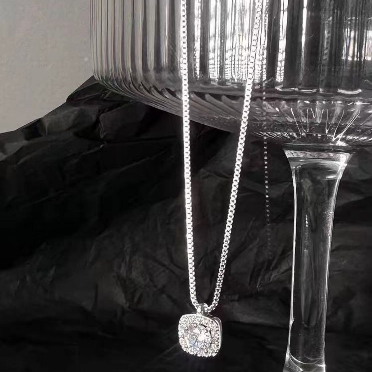 Sterling silver square pendant necklace with dazzling stones on a delicate chain.