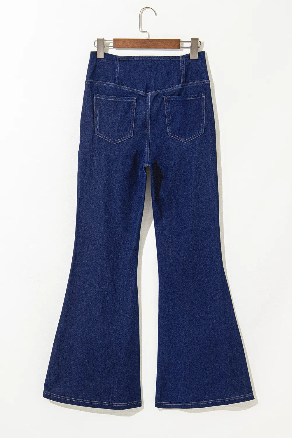 Medium wash denim flare trousers with crossover waist and back pockets.