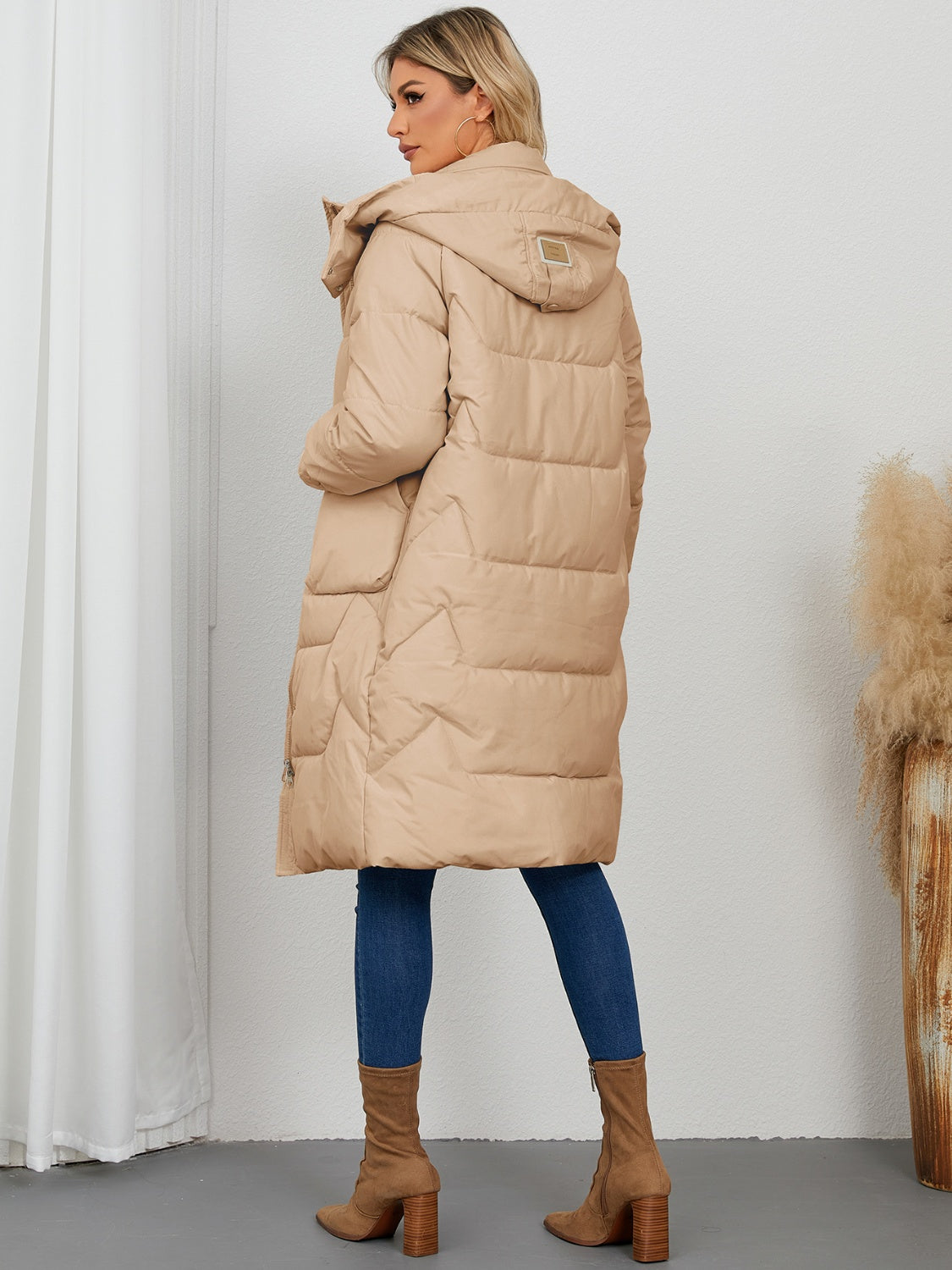 Camel quilted puffer parka with hood and buckle detail, long length.