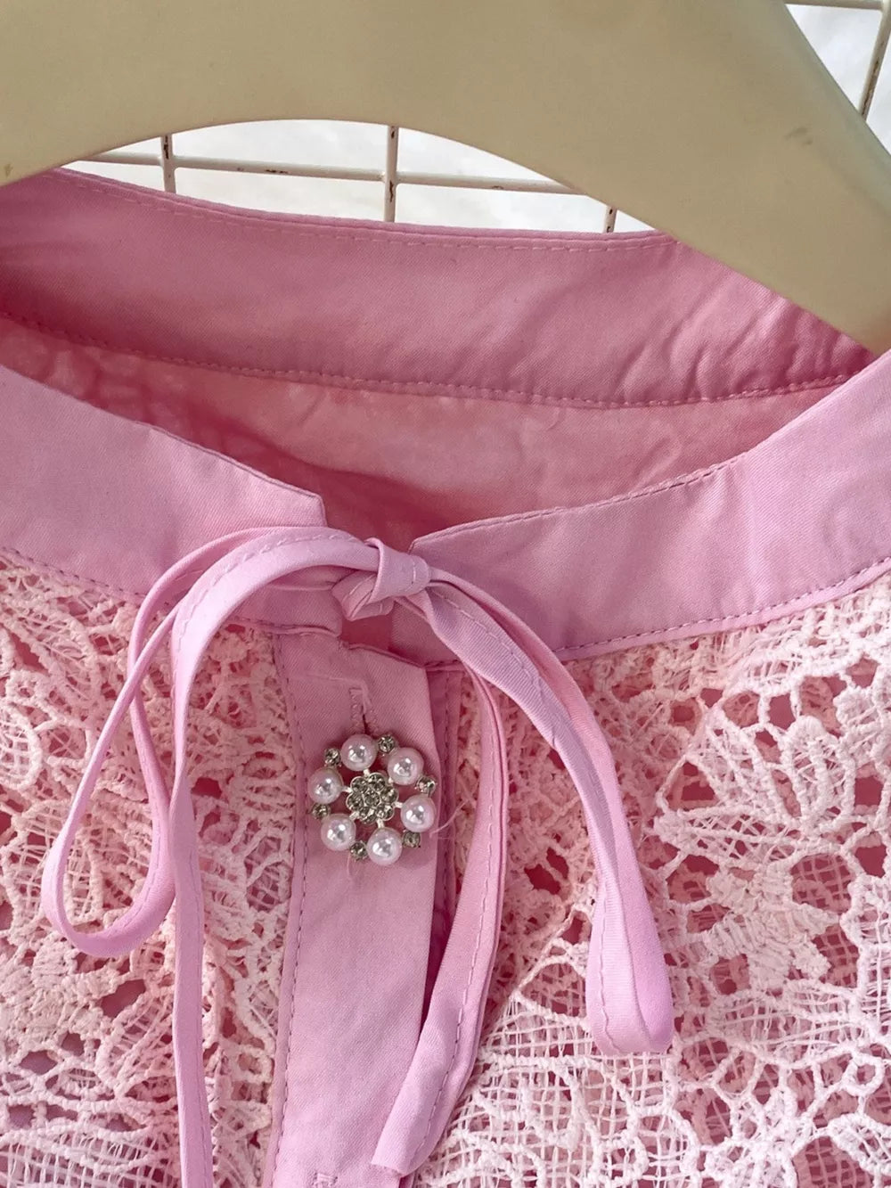 Blush pink lace two-piece ensemble with peplum, featuring a pearl and rhinestone brooch detail.