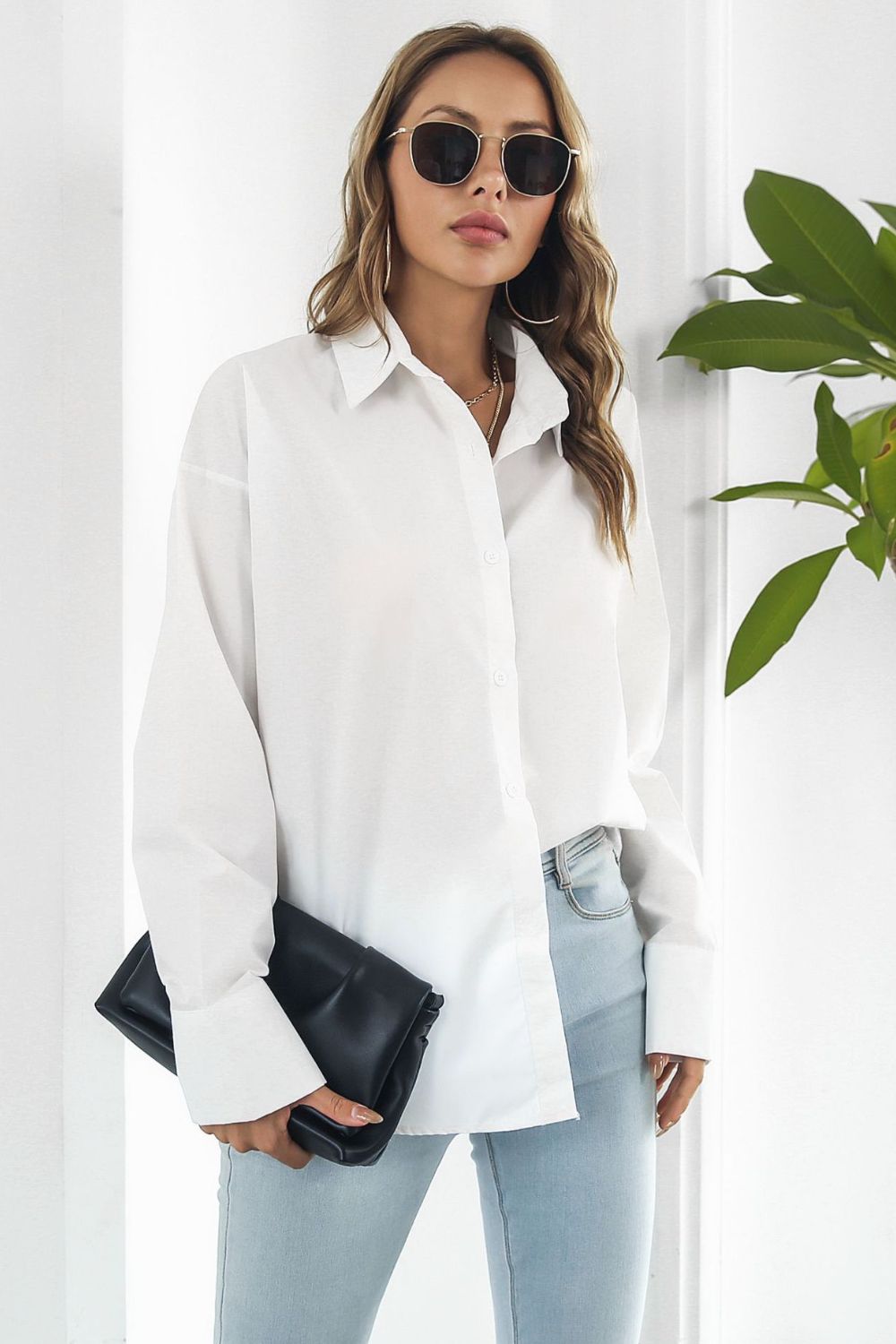 Oversized white cotton poplin button-up shirt with long sleeves and a classic collar.