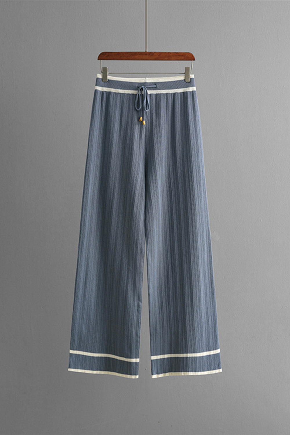 Dusty blue ribbed knit loungewear pants with contrast trim and drawstring waist.