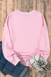 Blush pink crewneck sweatshirt with leopard bow graphic detail.