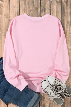 Blush pink crewneck sweatshirt with leopard bow graphic detail.