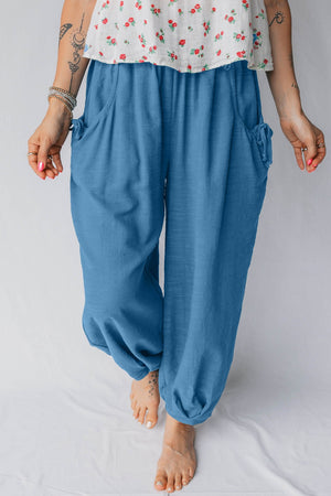 Blue cotton blend jogger pants with smocked waist, pockets, and drawstring details.