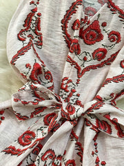 Tropical print two-piece set in pink with red embroidery and belted detail.