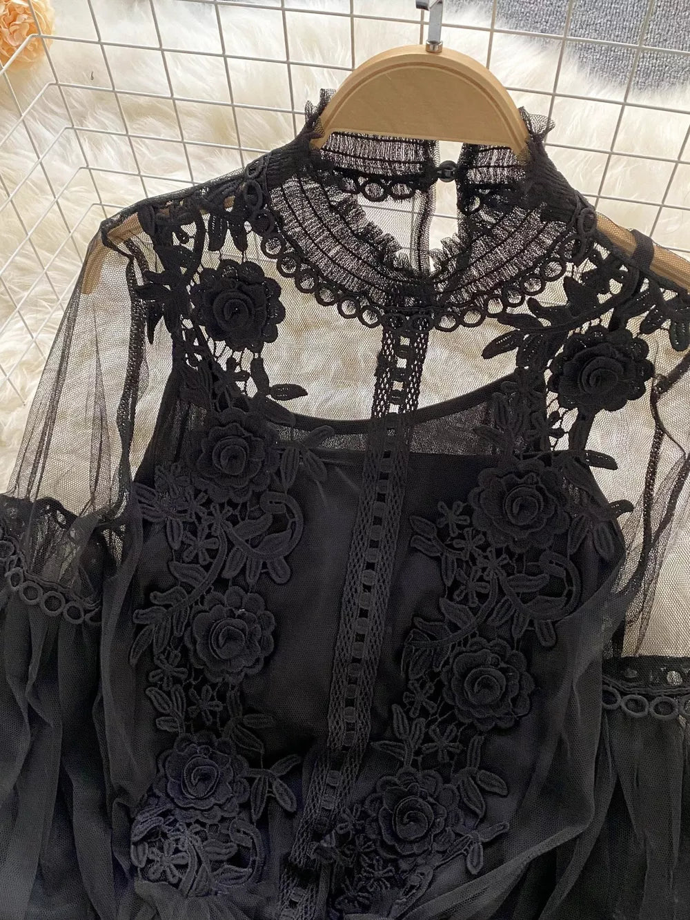 Black lace blouse with floral embroidery and sheer sleeves, paired with a cami.
