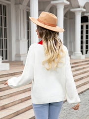 White acrylic sweater with red collar detail and heart intarsia pattern.