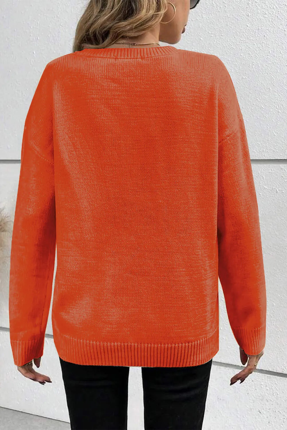 Orange crewneck sweater with appliqué detail, ribbed cuffs and hem.