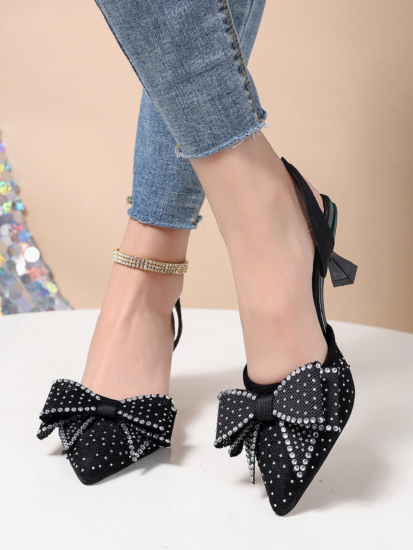 Black slingback heels with rhinestone bowknot detail and pointed toe