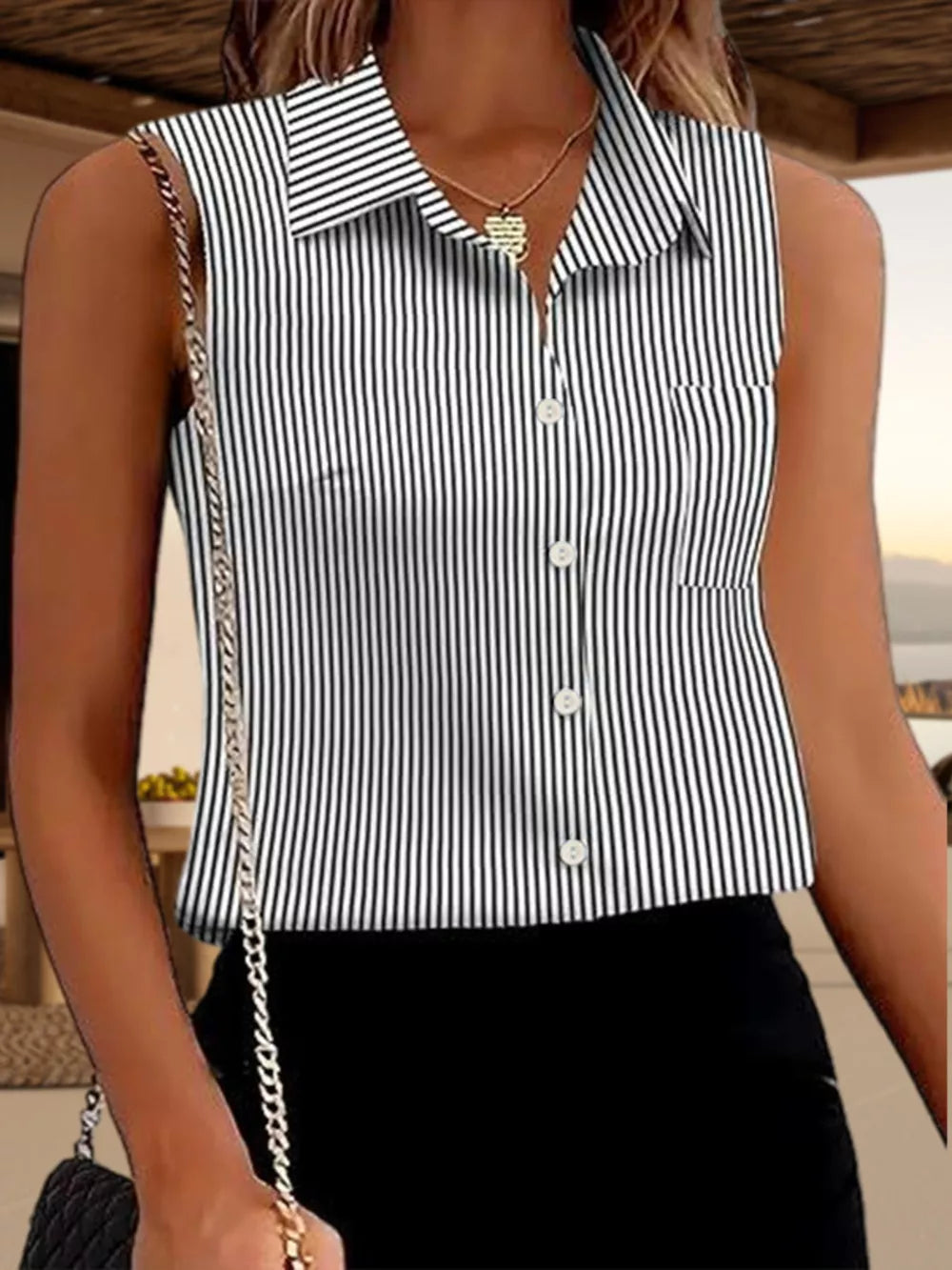 Sleeveless button-up blouse with black and white stripes and a pocket.