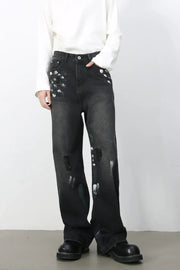 Painterly distressed wide-leg jeans in dark wash denim with artistic brushstroke details and ripped accents.